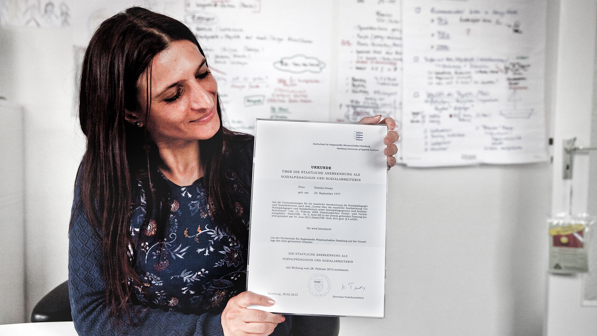 Sozialpädagogin Doinita Grosu hält ihr berufliches Anerkennungszertifikat in die Kamera