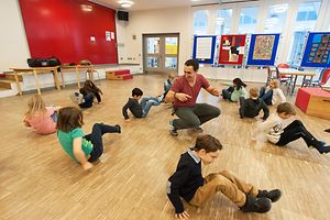 Lehrer beim Bewegungsunterricht mit Grundschulkindern