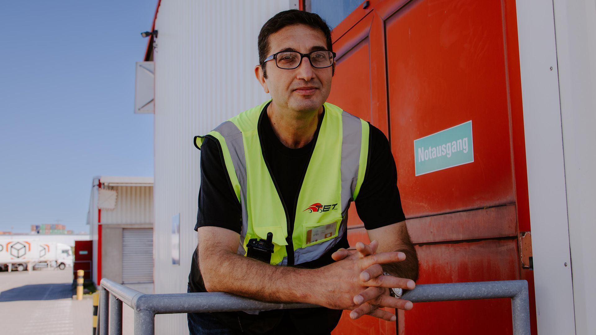 Irfan Efendioglu lehnt an seinem Arbeitsplatz im Logistikzentrum an einem Geländer