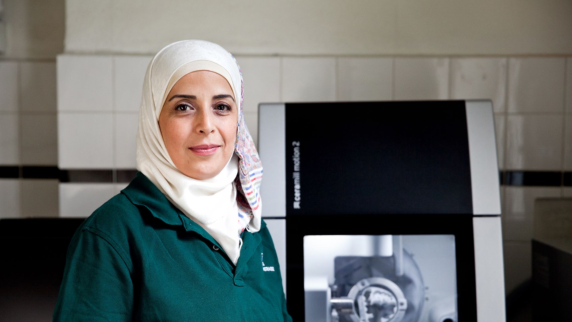 Zahntechnikerin Wessal Alkhalil steht im Dentallabor vor einem 3D-Drucker 